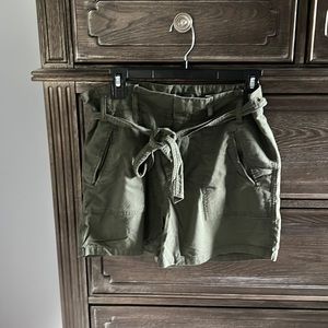 Army green button zip shorts with decorative tie.